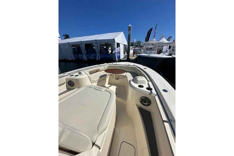 Slide: The Image of 2026 Scout 288 LXF boat interior at a marina, showcasing seating and amenities. - 7