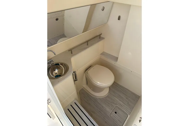 Slide: The Image of 2026 Scout 288 LXF boat bathroom with sink, toilet, and mirror. - 9