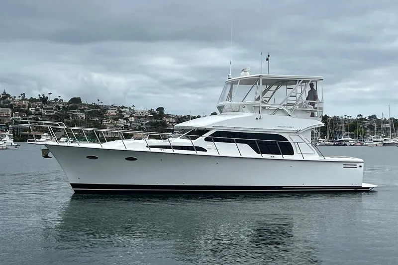 Slide: The Image of 2021 Mikelson Gen II 43 SF yacht on calm water, overcast sky, coastal backdrop. - 2