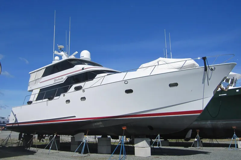 The Image of 1999 Delta Marine Raised Pilothouse Motoryacht on dry dock under clear blue sky. - 0