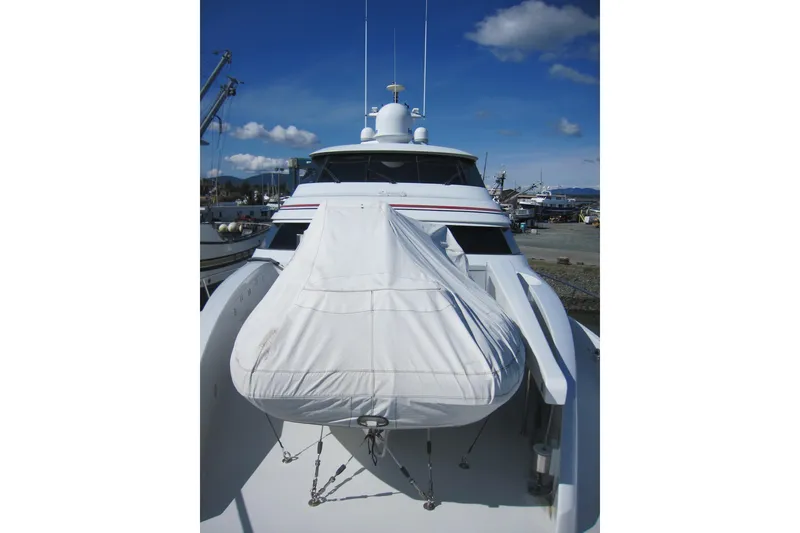 Slide: The Image of 1999 Delta Marine Raised Pilothouse Motoryacht with covered tender on deck, docked under blue sky. - 10
