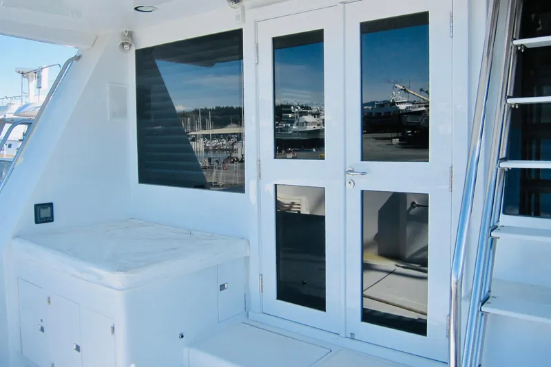 Slide: The Image of White Delta Marine Raised Pilothouse Motoryacht, 1999, featuring sleek doors and marina reflections. - 16