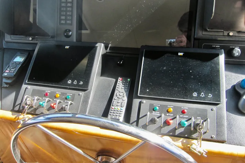 Slide: The Image of Control panel of a 1999 Delta Marine Raised Pilothouse Motoryacht with steering wheel and displays. - 30