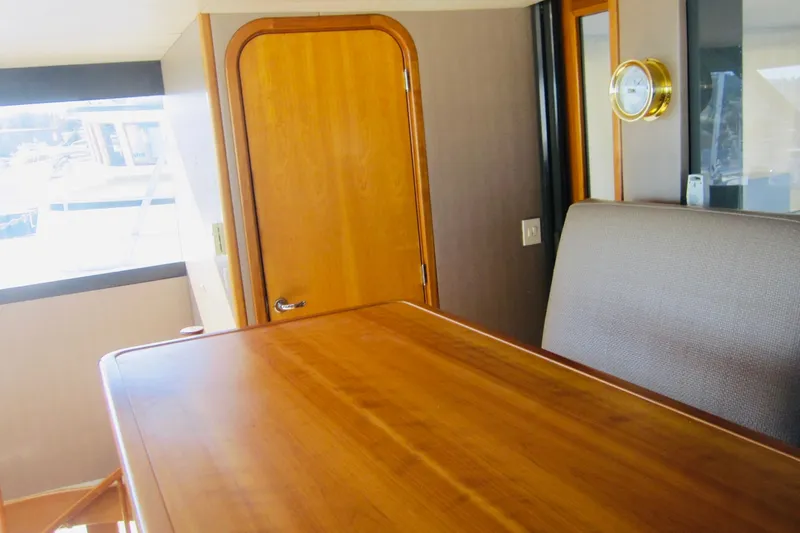 Slide: The Image of Interior of 1999 Delta Marine Raised Pilothouse Motoryacht with wooden table and door. - 31