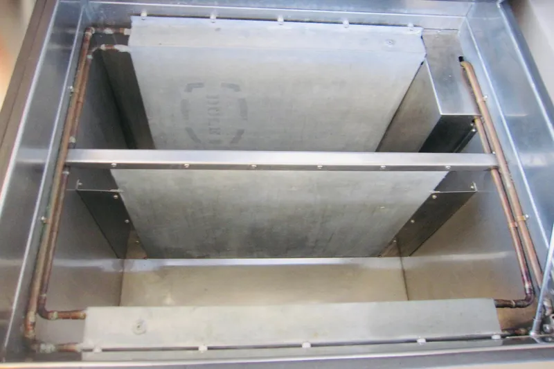 Slide: The Image of Engine compartment of 1999 Delta Marine Raised Pilothouse Motoryacht, showcasing metal components and piping. - 49