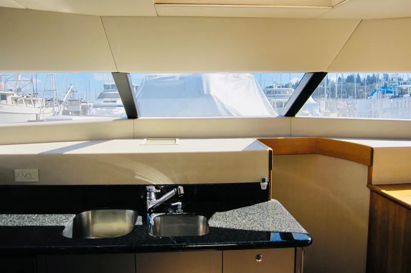 Slide: The Image of Interior view of 1999 Delta Marine Raised Pilothouse Motoryacht kitchen with sink and window. - 53