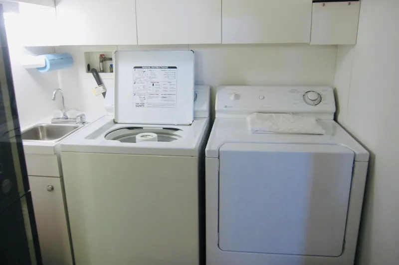 Slide: The Image of Laundry area on 1999 Delta Marine Raised Pilothouse Motoryacht with washer, dryer, and sink. - 77