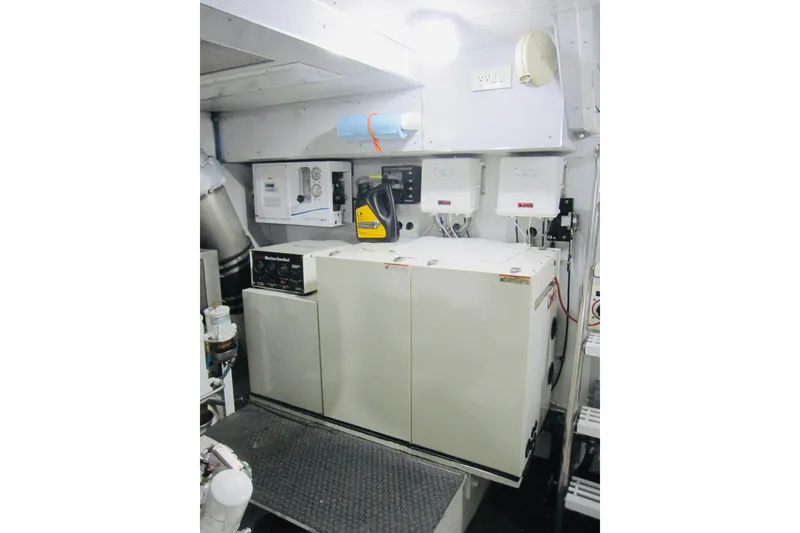 Slide: The Image of Engine room of 1999 Delta Marine Raised Pilothouse Motoryacht with equipment and control panels. - 84