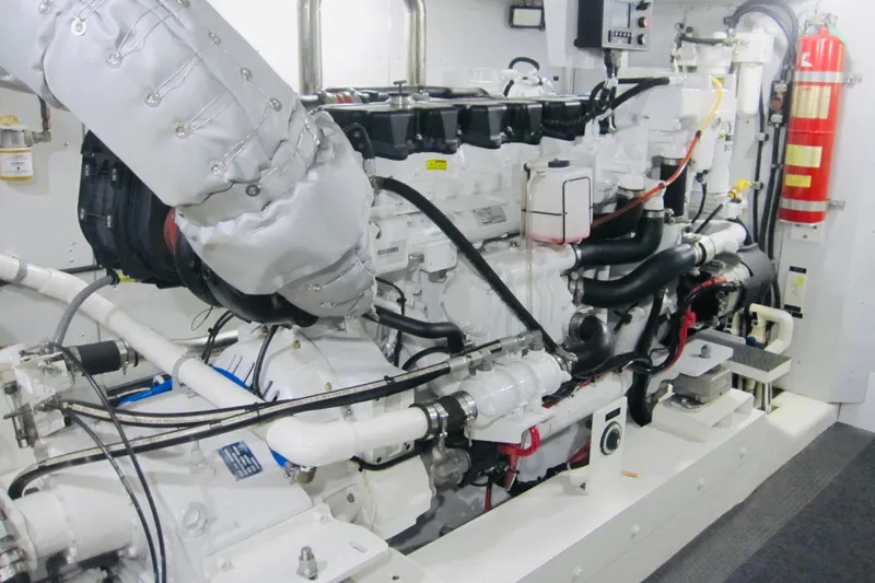 Slide: The Image of Engine room of 1999 Delta Marine Raised Pilothouse Motoryacht, featuring complex machinery and piping. - 89
