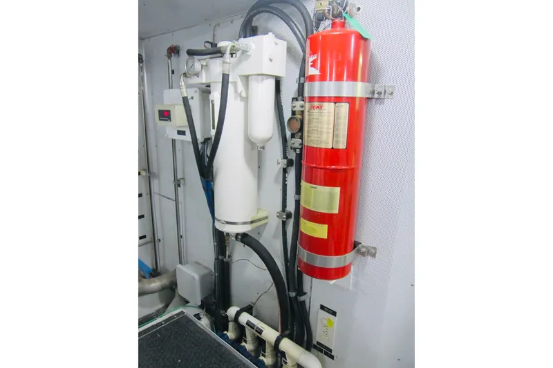 Slide: The Image of Engine room of 1999 Delta Marine Raised Pilothouse Motoryacht with fire extinguisher and equipment. - 91