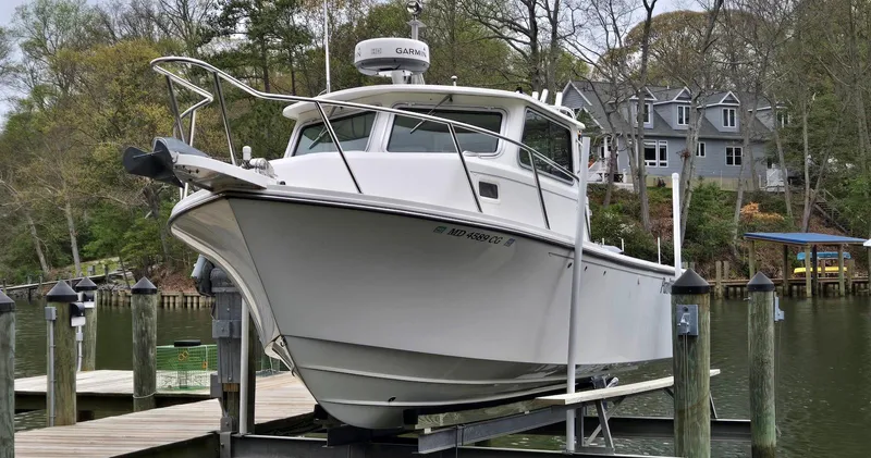 The Image of 2014 Parker 2520 XLD Sport Cabin boat docked near waterfront homes. - 0