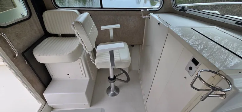 Slide: The Image of 2014 Parker 2520 XLD Sport Cabin interior with white seating and control panel. - 12