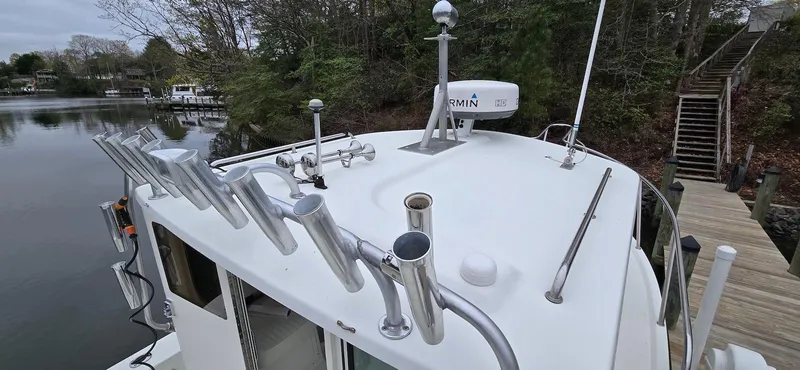 Slide: The Image of Parker 2520 XLD Sport Cabin 2014 boat with fishing rod holders and radar on the roof. - 13