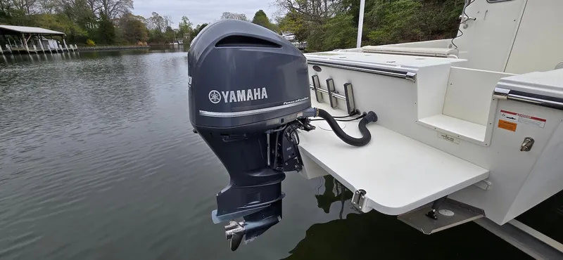 Slide: The Image of 2014 Parker 2520 XLD Sport Cabin with Yamaha outboard motor on a calm lake. - 2
