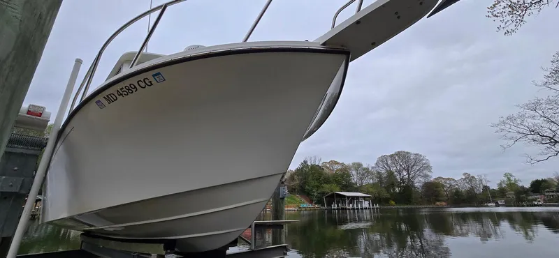 Slide: The Image of 2014 Parker 2520 XLD Sport Cabin boat docked by a serene lake. - 20