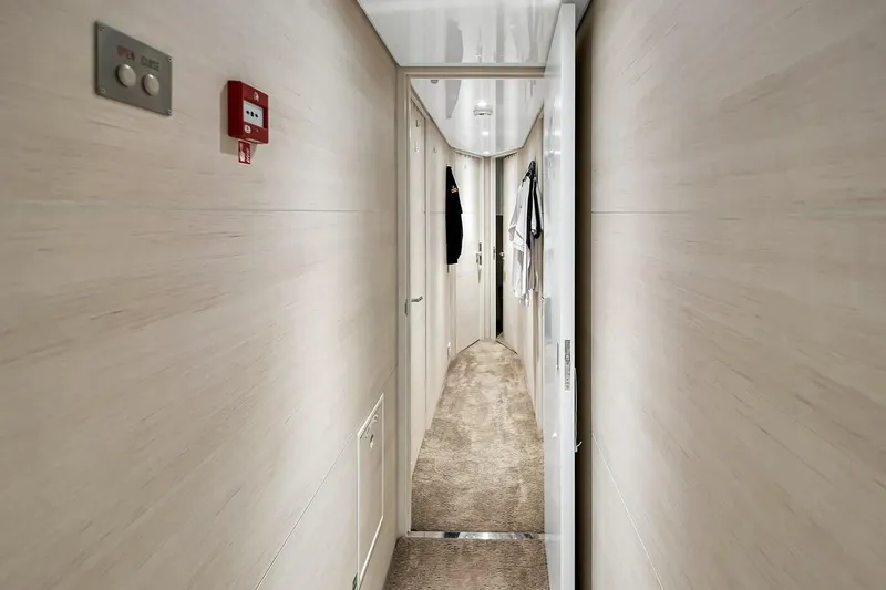 Slide: The Image of Narrow hallway inside 2024 Baglietto DOM 133 yacht, featuring modern design and light wood paneling. - 114