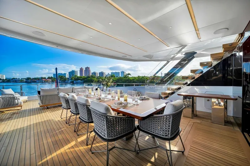 Slide: The Image of Luxurious 2024 Baglietto DOM 133 yacht deck with elegant dining setup and scenic waterfront view. - 49
