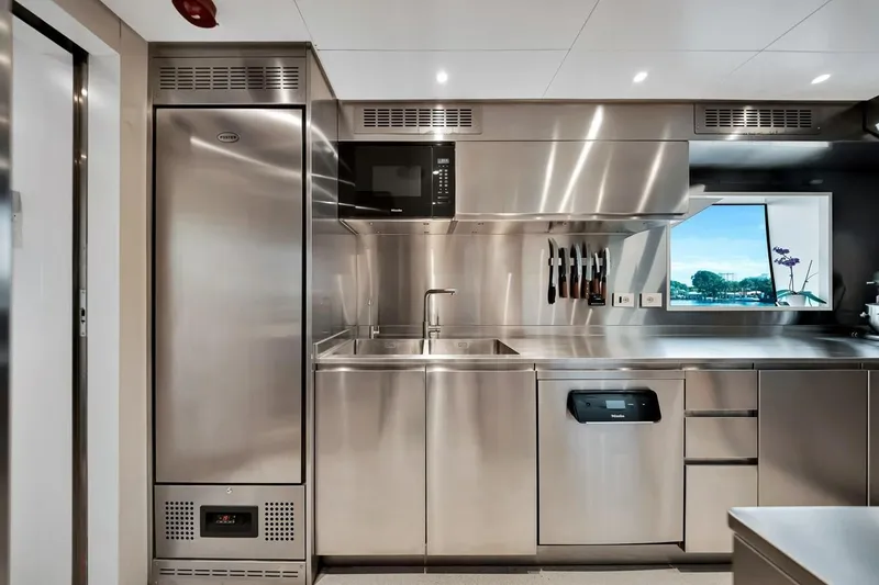 Slide: The Image of Modern stainless steel kitchen in 2024 Baglietto DOM 133 yacht, featuring sleek appliances and window view. - 69