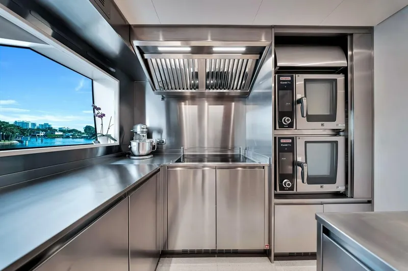 Slide: The Image of Modern stainless steel kitchen on 2024 Baglietto DOM 133 yacht with scenic window view. - 70