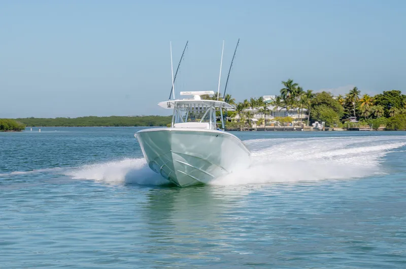 Slide: The Image of 2020 Contender 44ST boat cruising on clear water near tropical shoreline. - 2