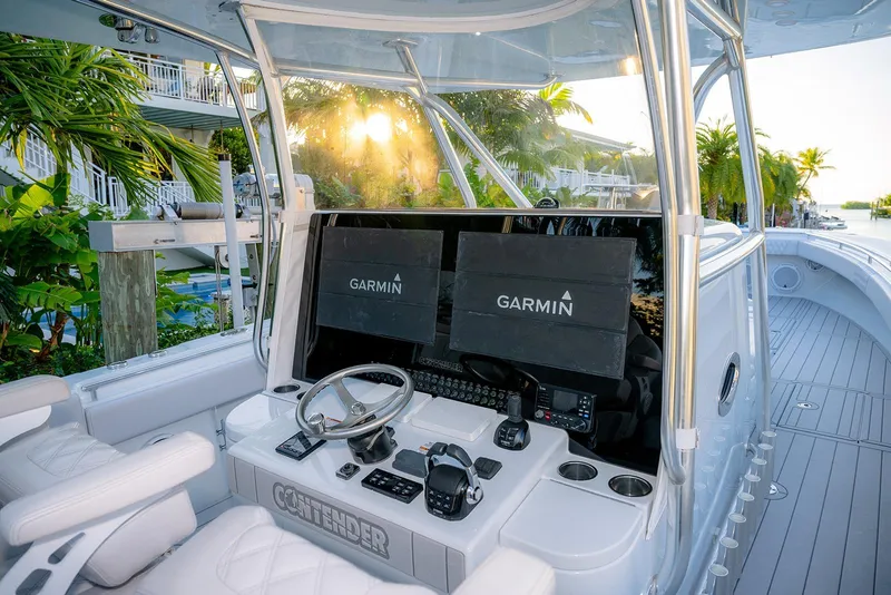 Slide: The Image of 2020 Contender 44 ST boat cockpit with Garmin navigation system, surrounded by tropical scenery. - 36