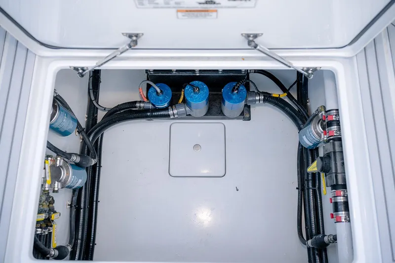 Slide: The Image of Engine compartment of a 2020 Contender 44 ST boat, showcasing fuel filters and hoses. - 37