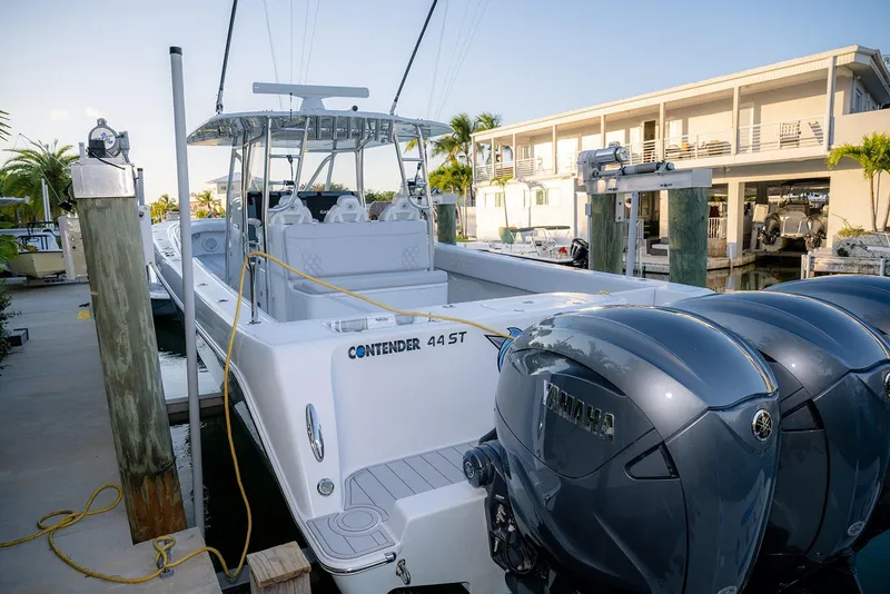 Slide: The Image of 2020 Contender 44 ST boat docked with Yamaha engines, featuring sleek design and spacious deck. - 38