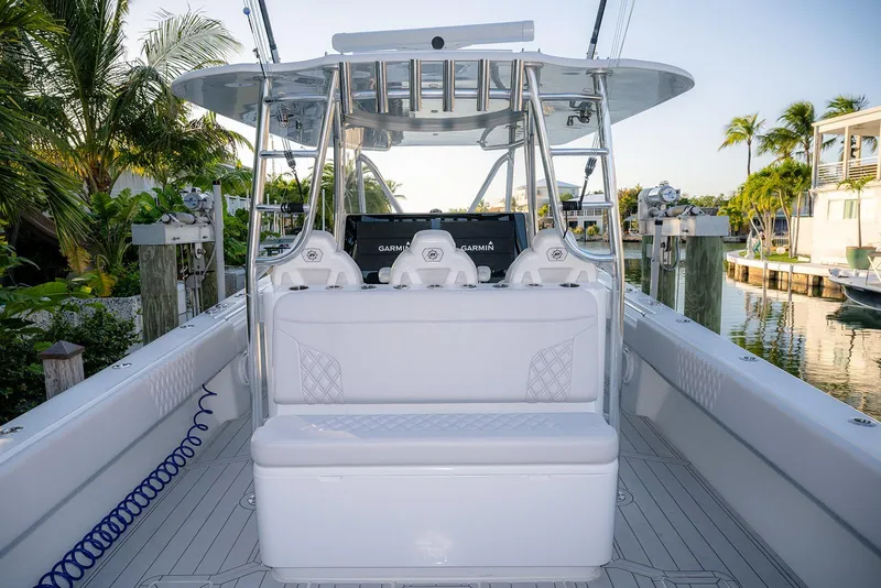 Slide: The Image of 2020 Contender 44 ST boat interior with seating and navigation equipment, docked near palm trees. - 6