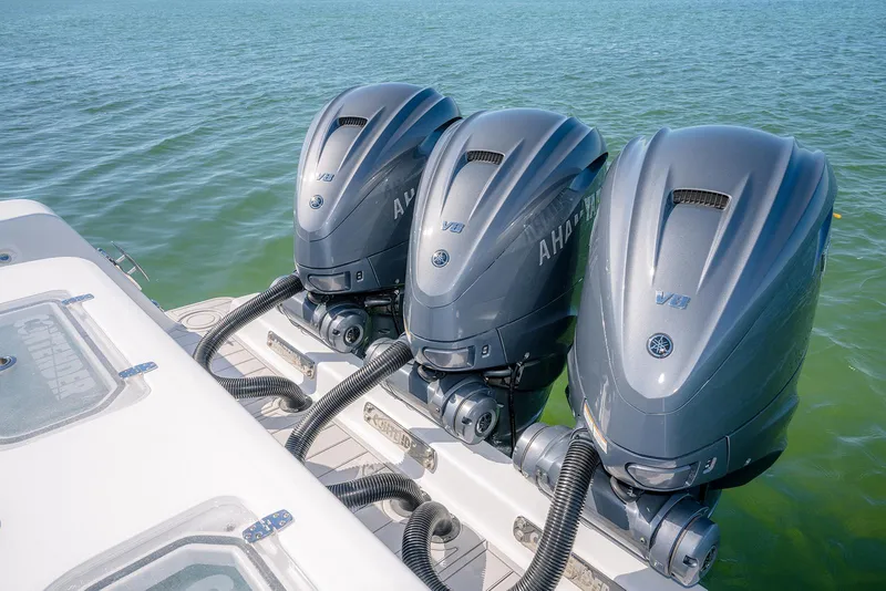 Slide: The Image of Triple Yamaha outboard engines on a 2020 Contender 44ST boat in calm waters. - 7