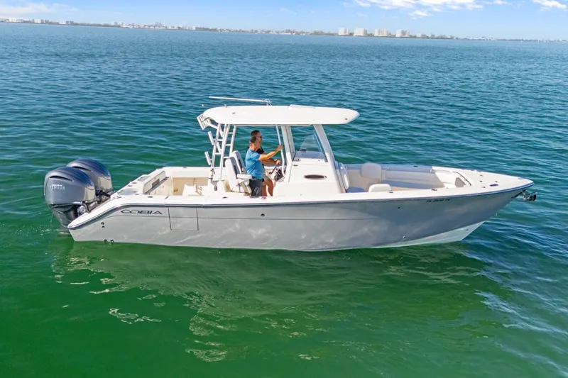 Slide: The Image of 2023 Cobia 301 Center Console boat cruising on open water. - 1