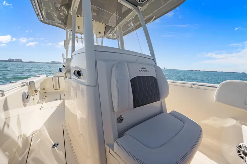 Slide: The Image of 2023 Cobia 301 Center Console boat on open water, showcasing seating and console design. - 15