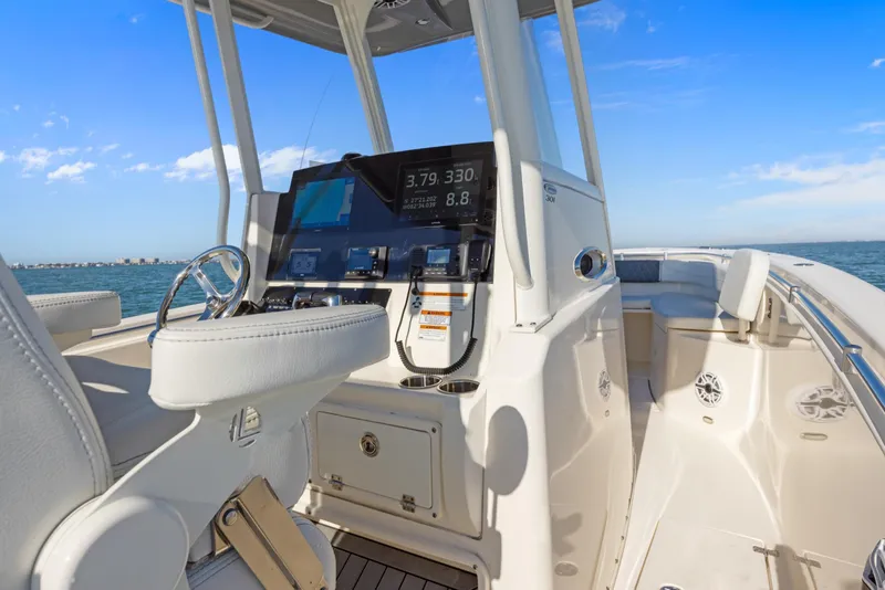 Slide: The Image of 2023 Cobia 301 Center Console boat interior with modern dashboard and ocean view. - 18