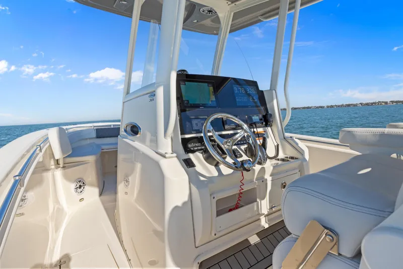 Slide: The Image of 2023 Cobia 301 Center Console boat interior with steering wheel and navigation system. - 19