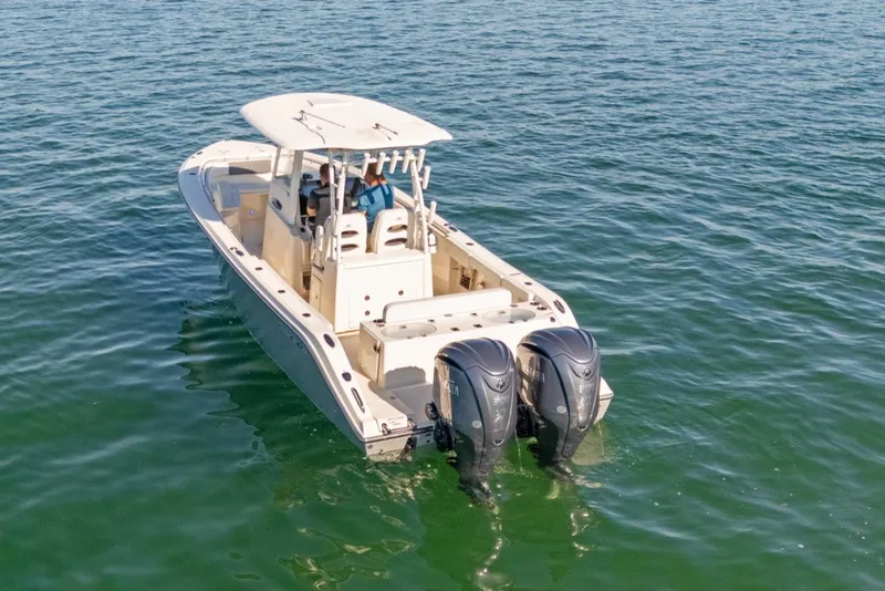 Slide: The Image of 2023 Cobia 301 Center Console boat with dual engines on open water. - 2