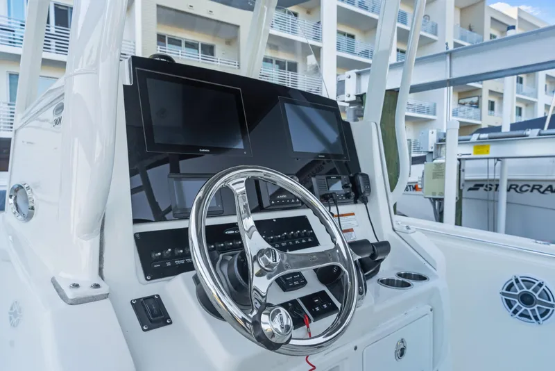 Slide: The Image of 2023 Cobia 301 Center Console boat dashboard with steering wheel and navigation screens. - 21
