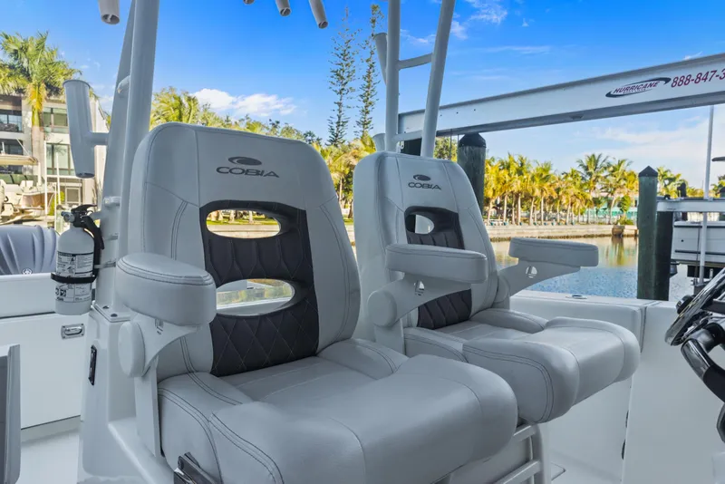 Slide: The Image of 2023 Cobia 301 Center Console boat seats with armrests, dockside view. - 22