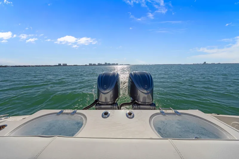 Slide: The Image of 2023 Cobia 301 Center Console boat with dual engines on open water. - 25