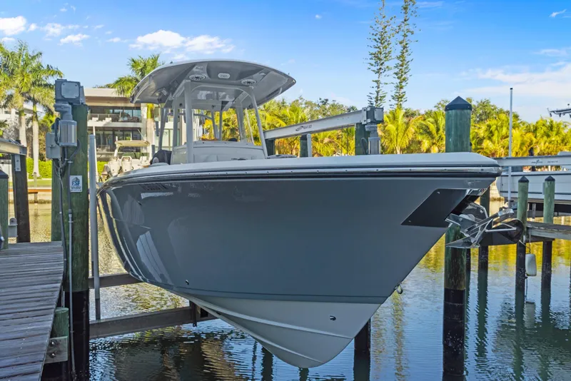 Slide: The Image of 2023 Cobia 301 Center Console boat docked in a sunny marina setting. - 28
