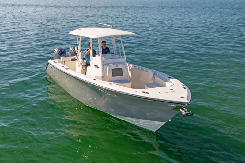 Slide: The Image of 2023 Cobia 301 Center Console boat cruising on clear blue water. - 3