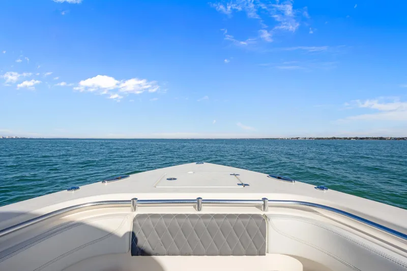 Slide: The Image of 2023 Cobia 301 Center Console boat on open water under clear blue sky. - 8