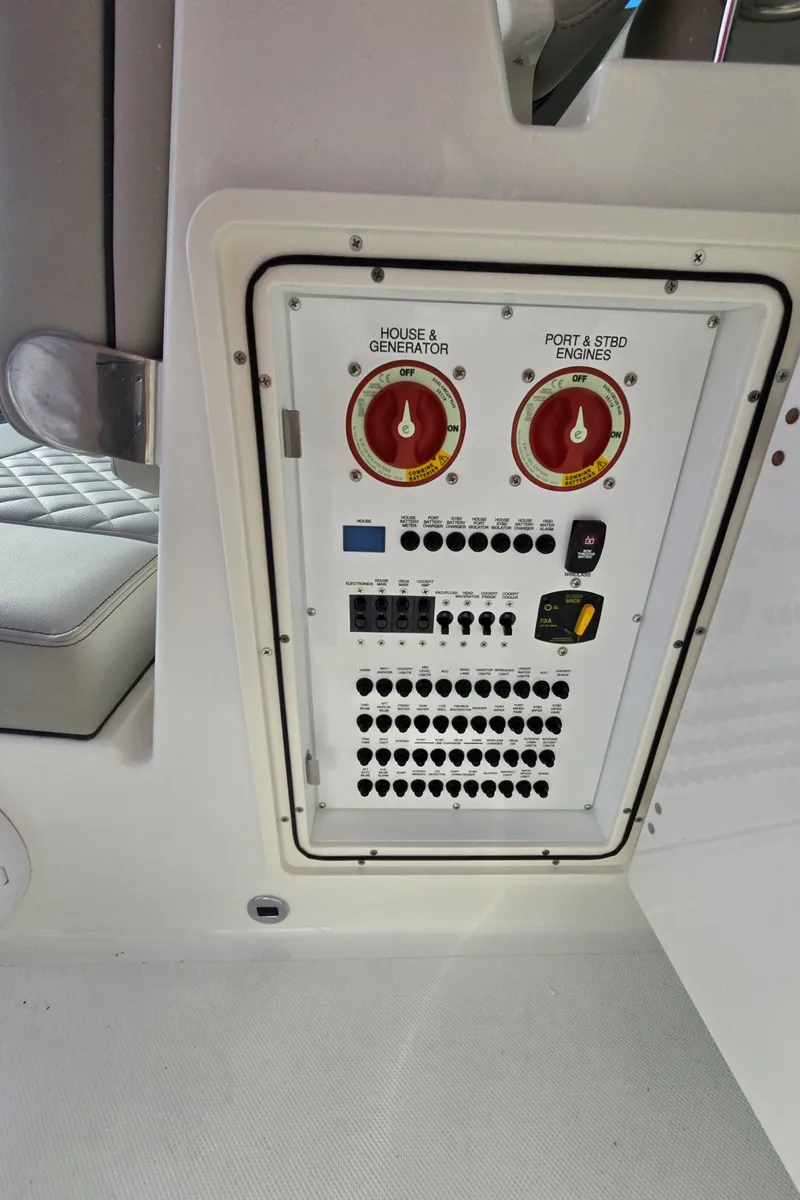 Slide: The Image of Control panel of 2025 Pursuit DC 326 boat with switches and gauges. - 11
