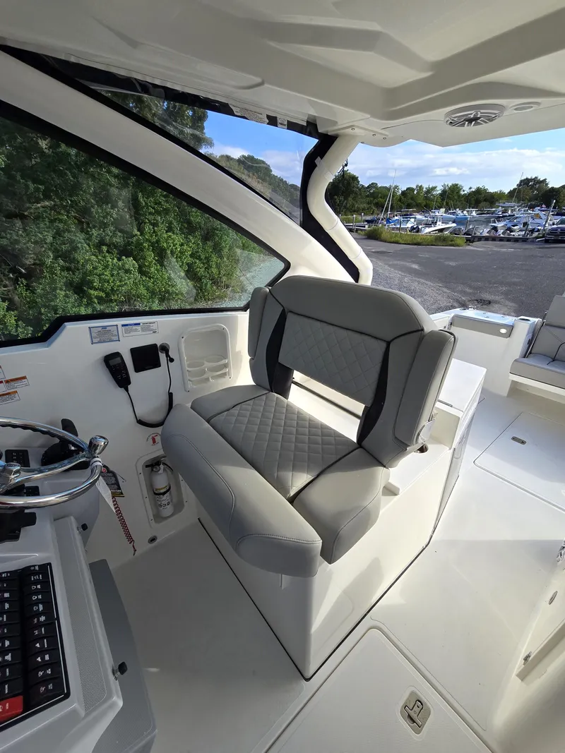 Slide: The Image of Interior of 2025 Pursuit DC 326 boat with luxurious seating and modern controls. - 13