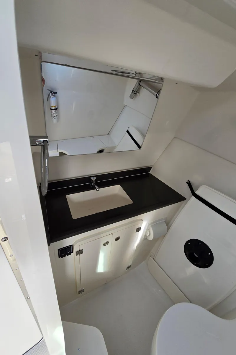 Slide: The Image of 2025 Pursuit DC 326 boat bathroom with modern sink and mirror. - 18