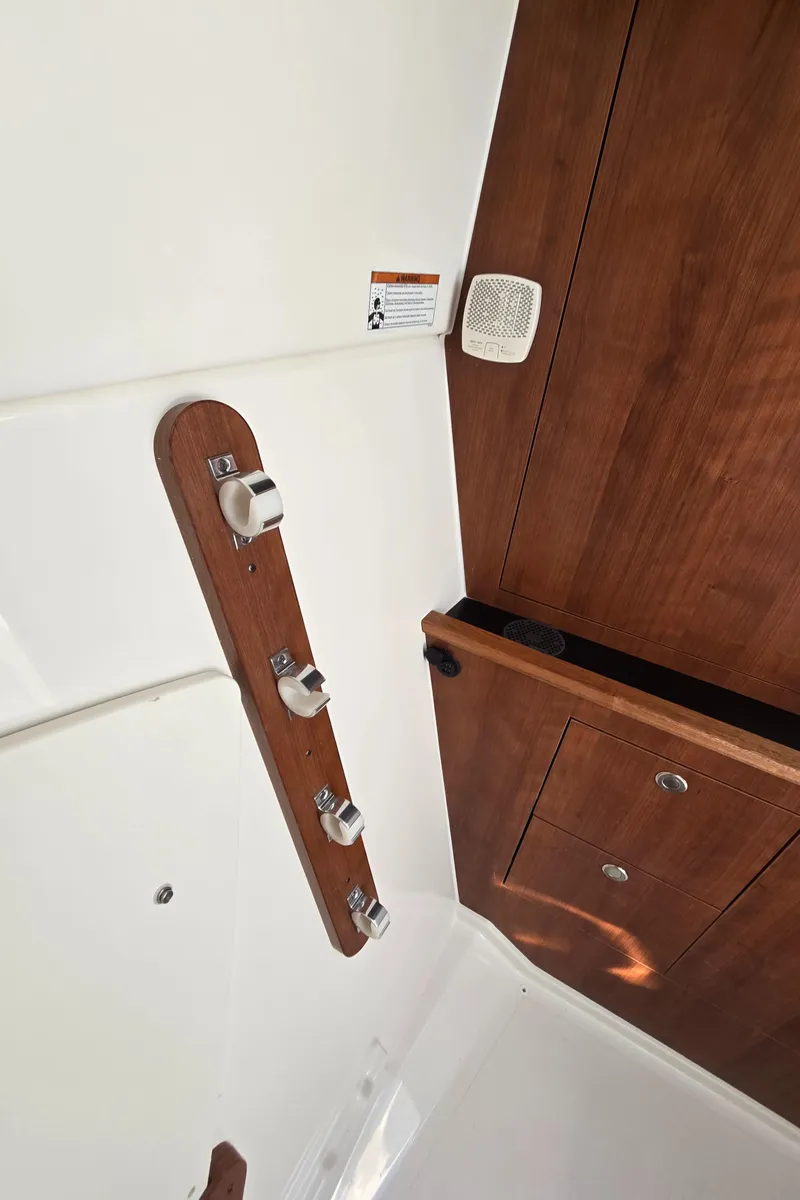 Slide: The Image of Interior of 2025 Pursuit DC 326 boat with wooden paneling and control switches. - 21