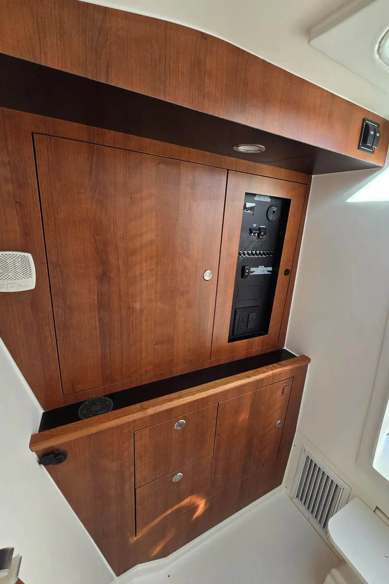 Slide: The Image of Wooden interior paneling of 2025 Pursuit DC 326 boat with control panel. - 22