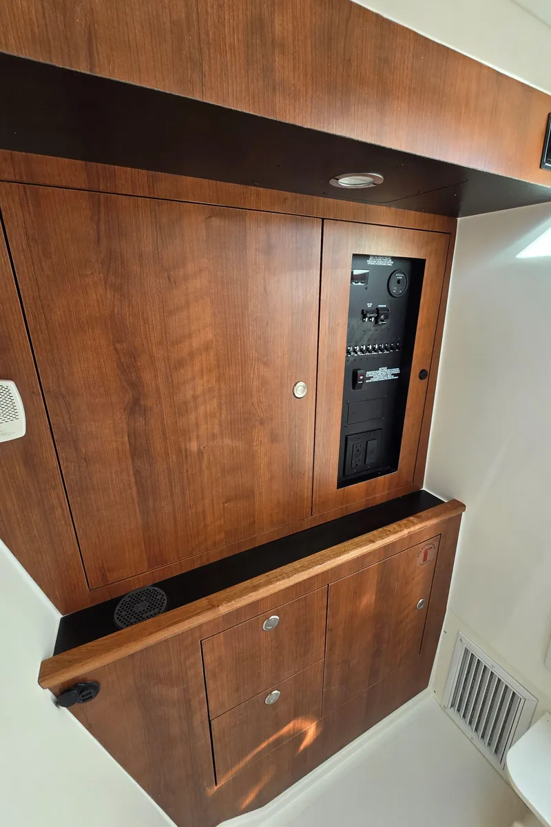 Slide: The Image of 2025 Pursuit DC 326 interior with wooden cabinetry and control panel. - 23