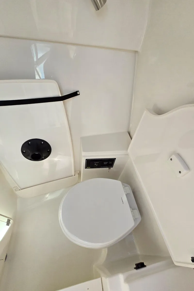 Slide: The Image of 2025 Pursuit DC 326 boat interior bathroom with modern white fixtures. - 29