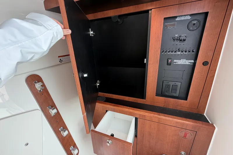 Slide: The Image of Interior view of 2026 Pursuit DC 326 Dual Console's wooden cabinet with electrical panel. - 31