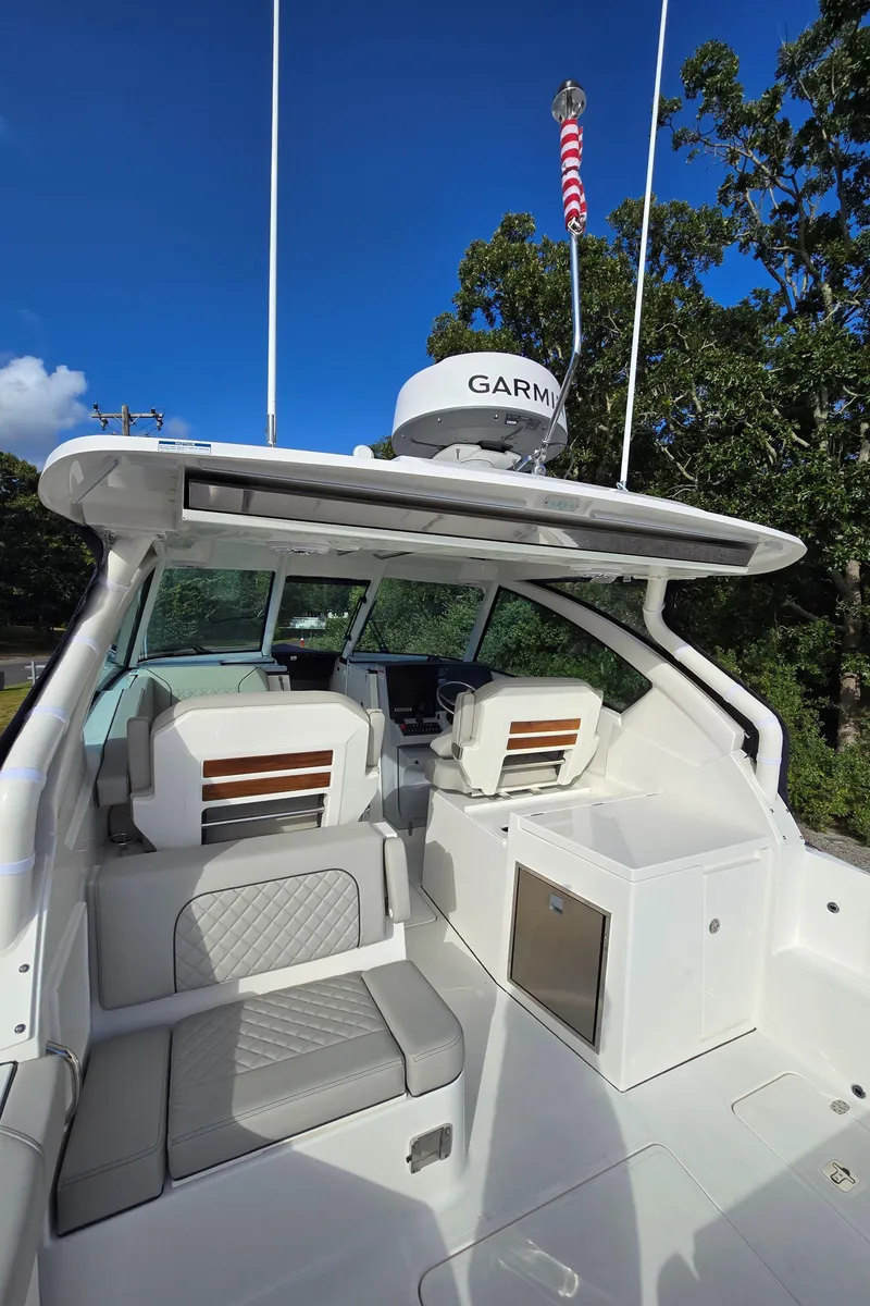 Slide: The Image of 2025 Pursuit DC 326 boat interior with seating and Garmin equipment. - 4