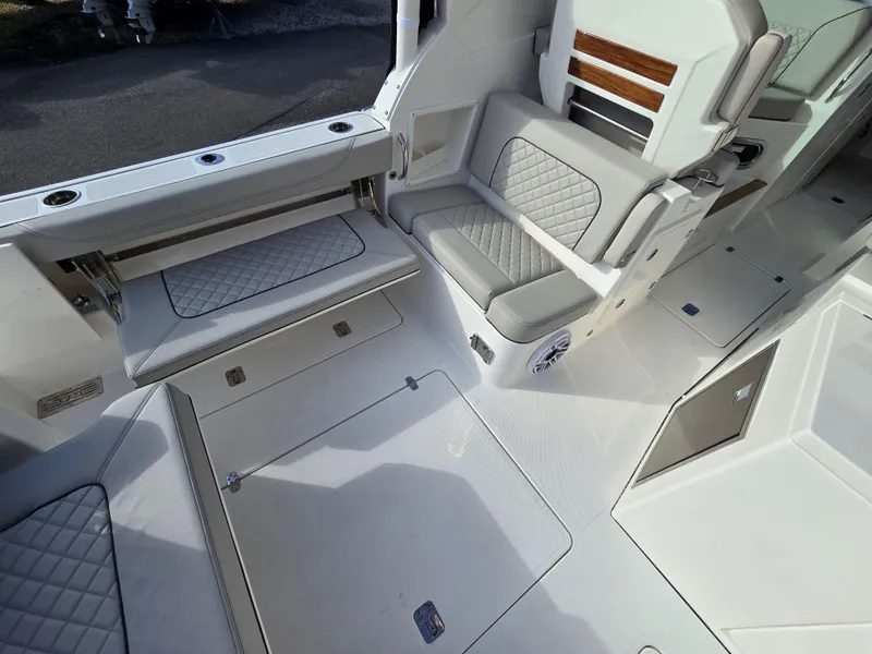 Slide: The Image of 2025 Pursuit DC 326 boat interior with cushioned seating and sleek design. - 8